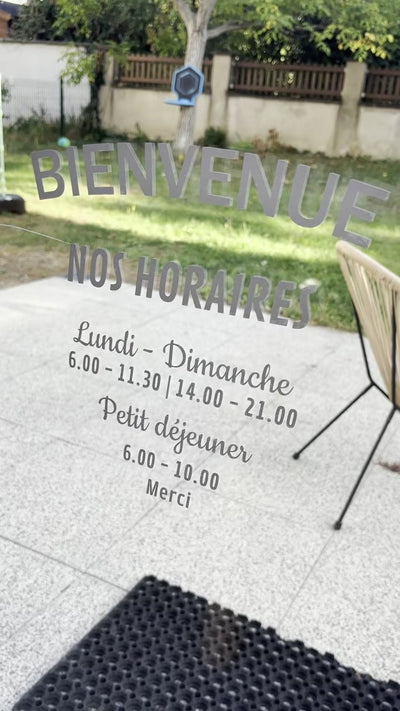 Sticker horaires posé sur une vitrine