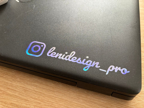Sticker holographique personnalisé @lenidesign_pro sur ordinateur portable noir