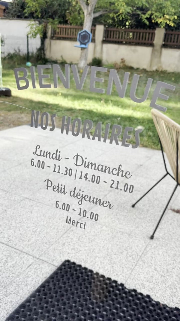 Sticker horaires posé sur une vitrine