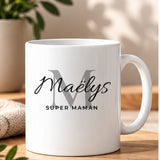 Mug blanc personnalisé Mug Prénom Signature, style Monogramme : grande initiale atténuée, prénom Maëlys en écriture Allura et petite phrase Super Maman en noir
